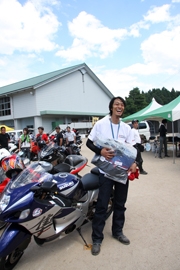 一番遠くからやって来たライダーにはスズキからプレゼントが。北海道は旭川からの参加です。「旅の途中じゃなくて、この祭りのために走ってきました」と。エラいぞ！※写真をクリックすると、ナビには「彼女の大好物なんです」が巻き付けてあります。