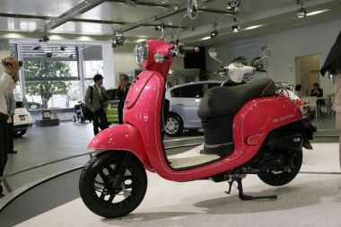 ホンダモーターサイクルジャパンが提案する参考展示モデル「ジョルノ・エレガントスタイル」。鮮やかなキャンディーコスモスピンクのボディやバックミラーに、クリスタル調のラインが施される。携帯電話のデコレーションのように、女性の好みをより特化させた１台。フロアステップにはムートン調のマットが敷かれている。