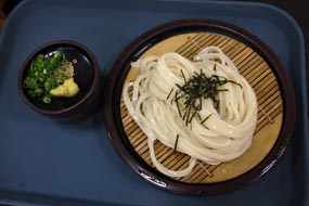 中井PAのうどんである。近頃カトキチ（中尾の故郷、讃岐にある）の冷凍うどんが人気だが（たしかに美味い）、ここんちは“手打ち”なのだ。「茹で上がるまで少々時間がかかります」のですよ。嬉しい時間待ちなのだよ。いわゆるセルフってシステムでだから、トッピングなんぞを自分で、すなわちセルフで選んで会計を済ませる。幸江さんはざるうどんだ。江戸っ子だね……青森・八戸出身ですが、何か？　※写真をクリックすると、「喰った喰った！」が見られます。