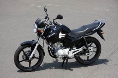 ヤマハYBR125。YBR250ではシート下にちょっとした収納スペースが作られているが、こちらYBR125ではシートはボルト止めでサイドカバーが開く。バッテリーの上部に工具と書類が入れられる。